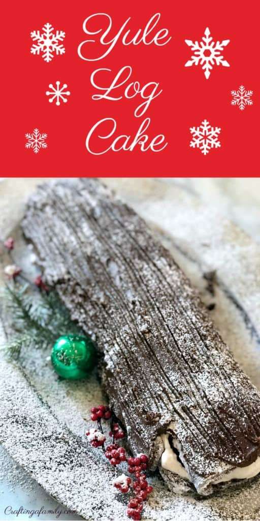 Christmas Yule Log Cake Recipe on a platter with a green christmas bulb and powdered sugar on the log and on the counter