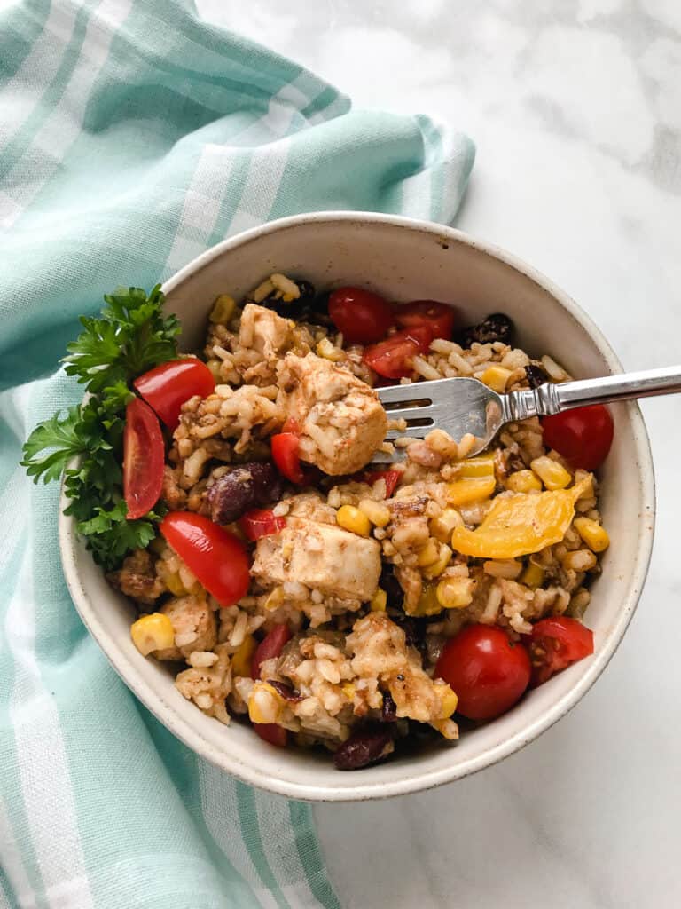 Instant Pot Taco Mexican Chicken & Rice gray bowl on a mint green towel chicken and rice with beans peppers and fork