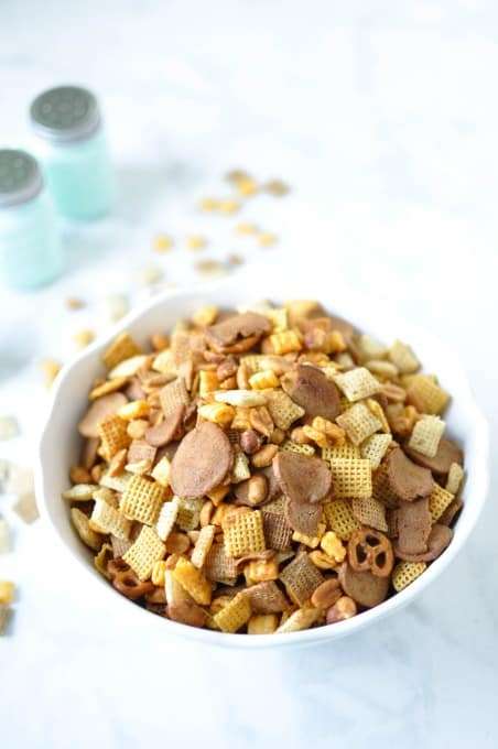 After School Snacks Chex mix in a white bowl with chex mix on the counter.