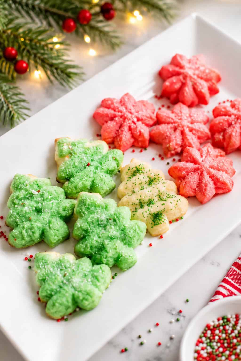 9 spritz cooked on a whit plate decorated with green sprinkles.