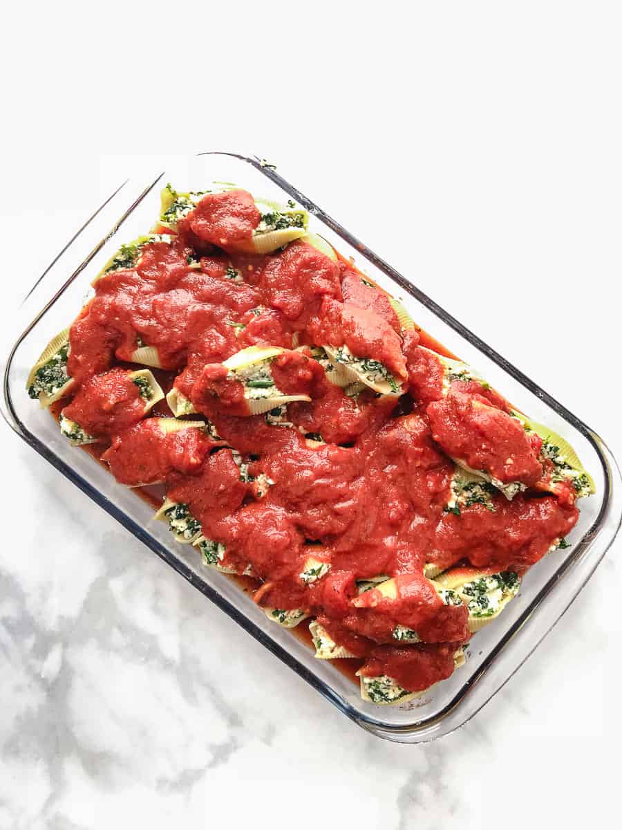Easy Vegetarian Stuffed Shells Spinach and Ricotta Cheese dealer baking dish with tomato sauce on top ready for the oven top down view. 