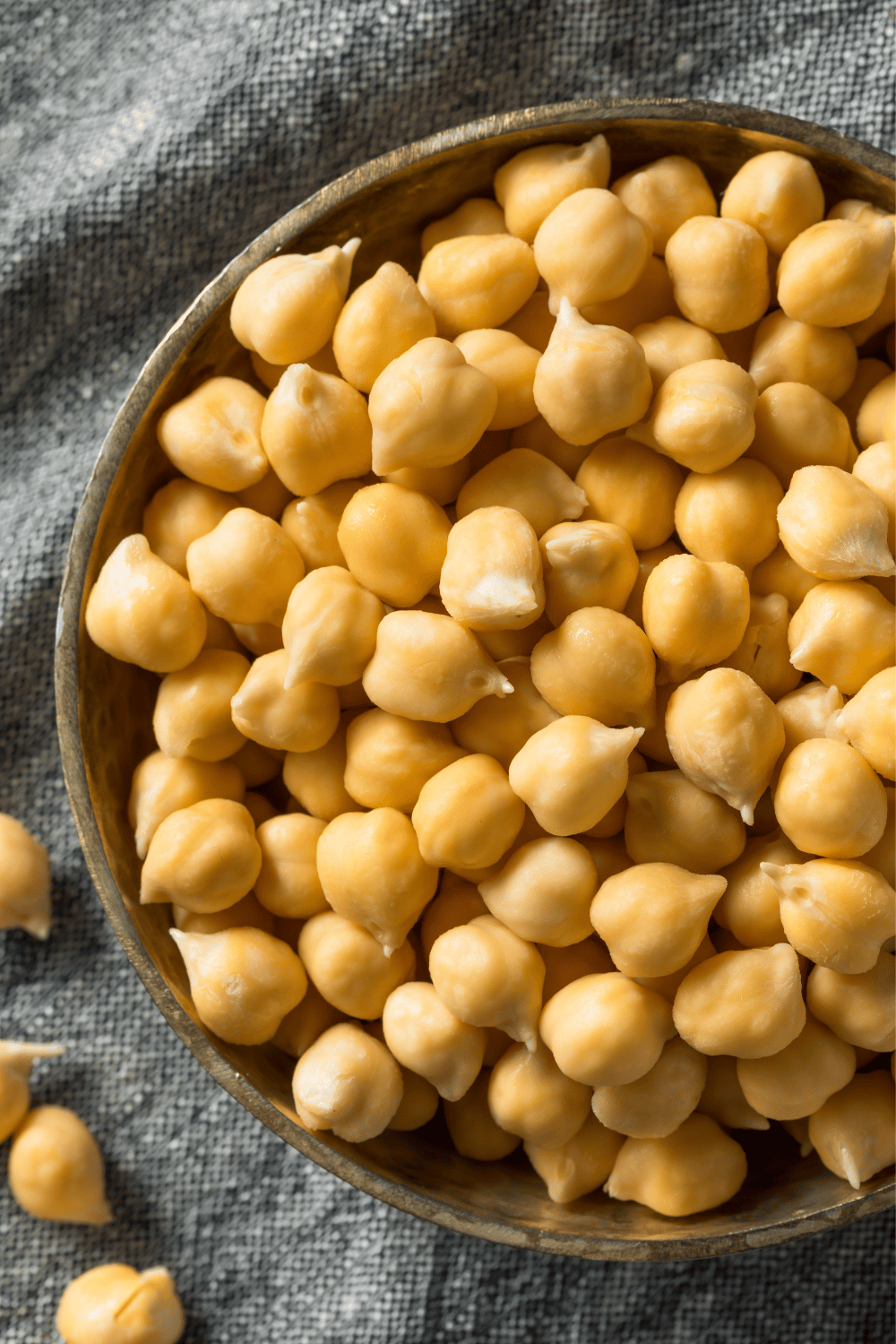 chickpeas or garbanzo beans in a brown bowl on a gray napkim