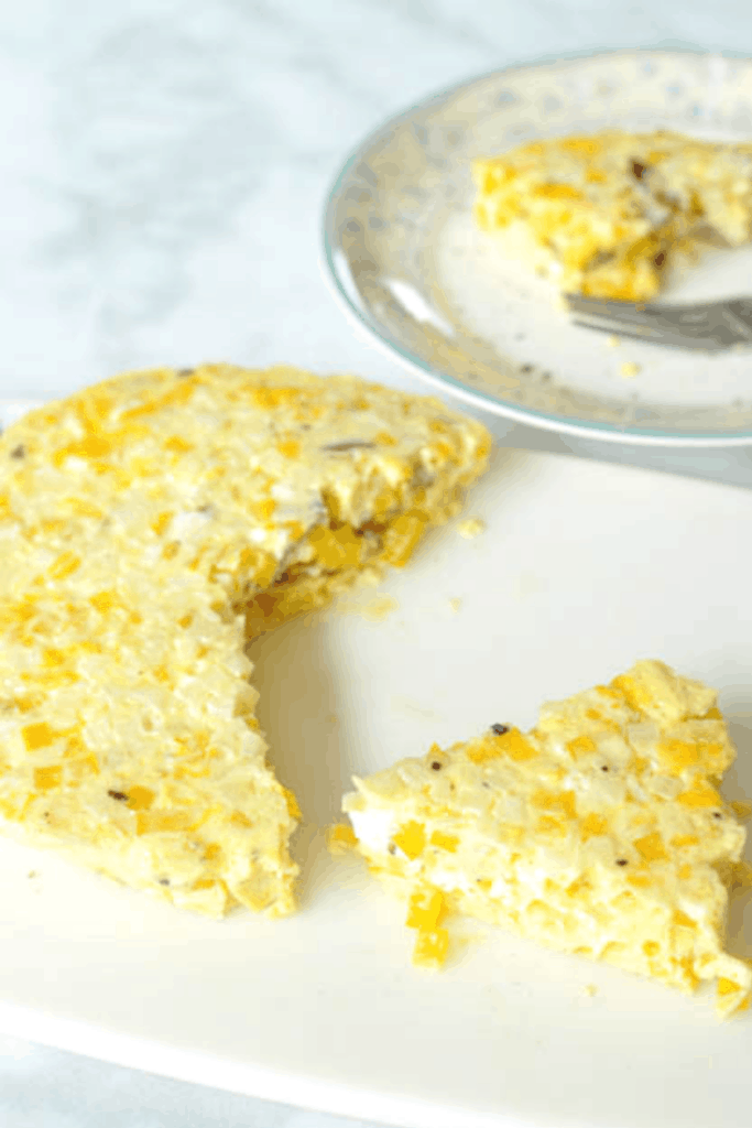 Instant Pot Egg Frittata Quick and Easy on a white cutting board and a slice on a small plae 