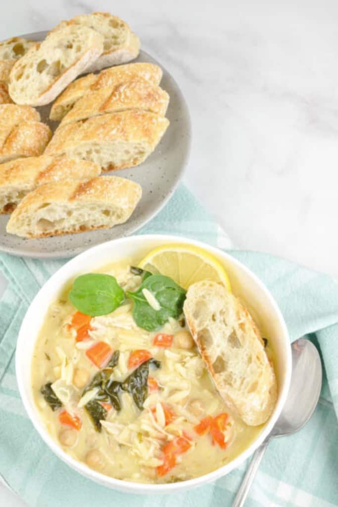 Lemon chicken orzo chickpea soup with spinach in a bowl