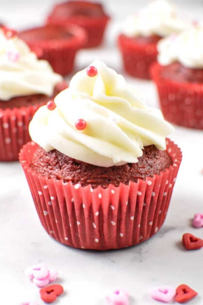 red velvet cupcakes on a white counter with white frosting