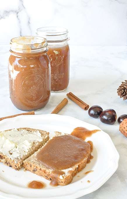The best homemade instant pot apple butter on bread and two Ball jars filled with apple butter a slice of bread with butter and apple butter on it