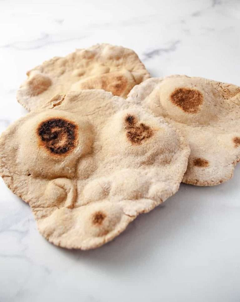 3 cooked naan bread on white counter