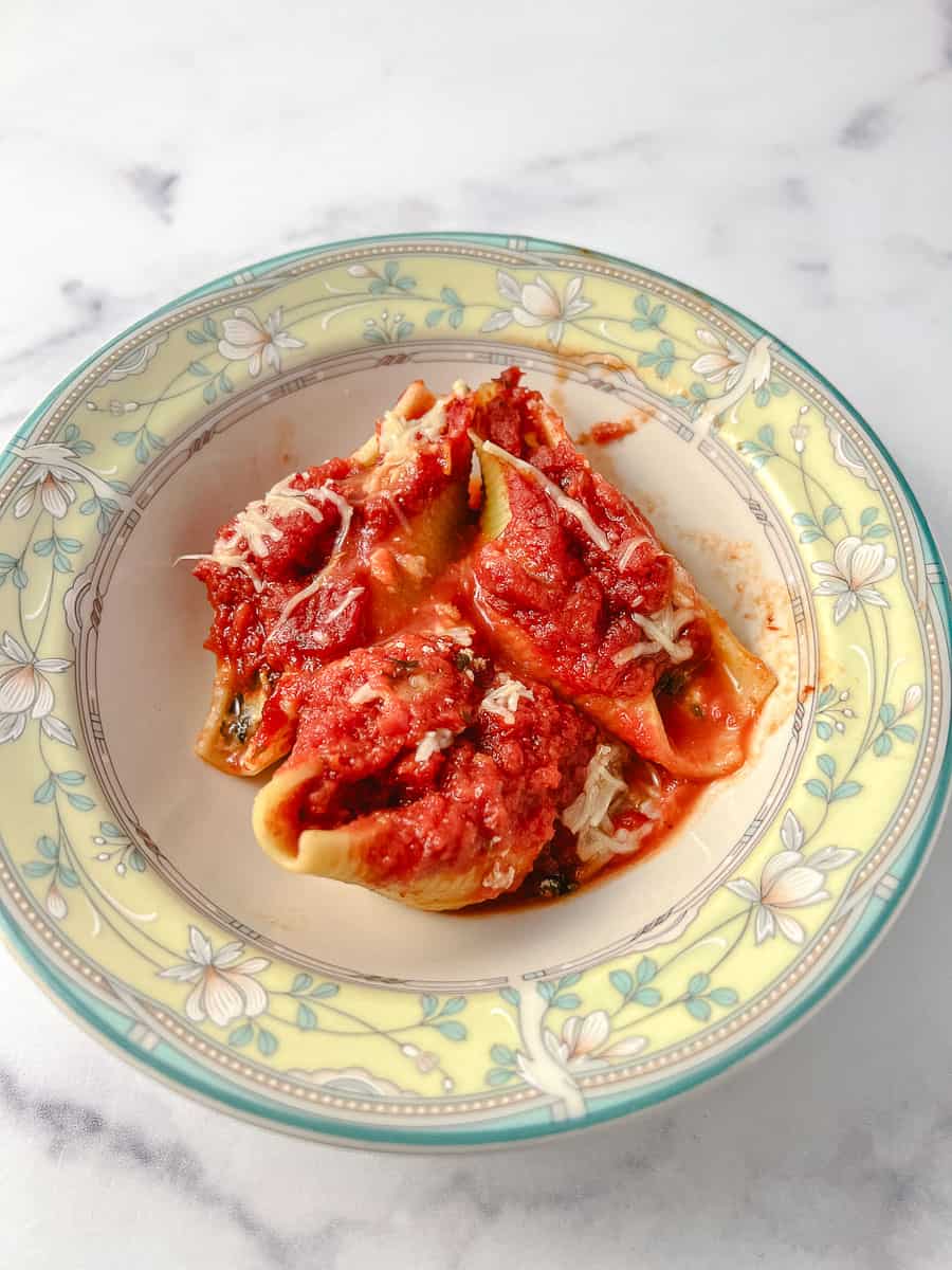 Easy Vegetarian Stuffed Shells Spinach and Ricotta Cheese 3 in a yellow and green flowered rim bowl on a marble counter. 