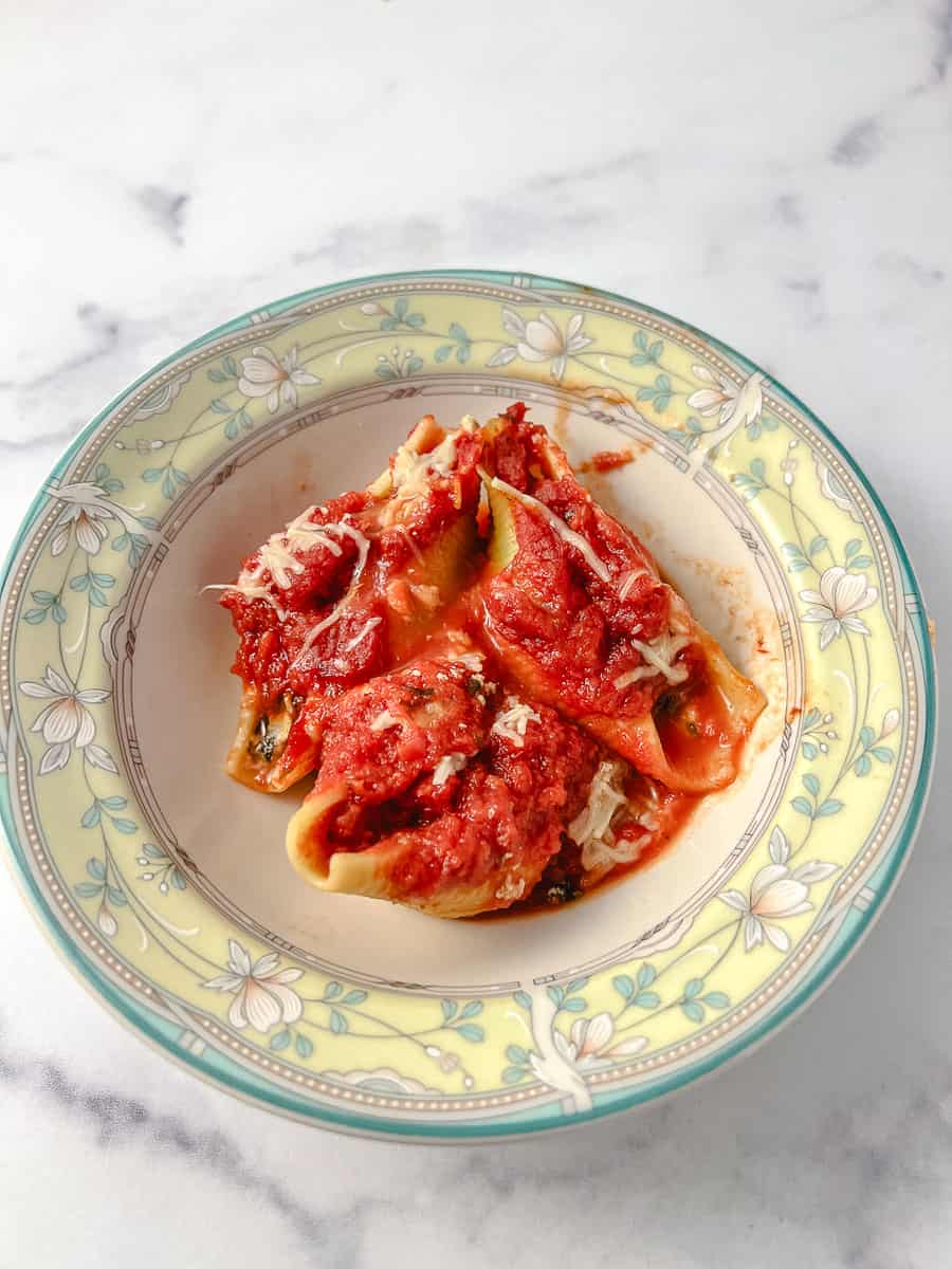 Easy Vegetarian Stuffed Shells Spinach and Ricotta Cheese 3 in a yellow and green flowered rim bowl on a marble counter.