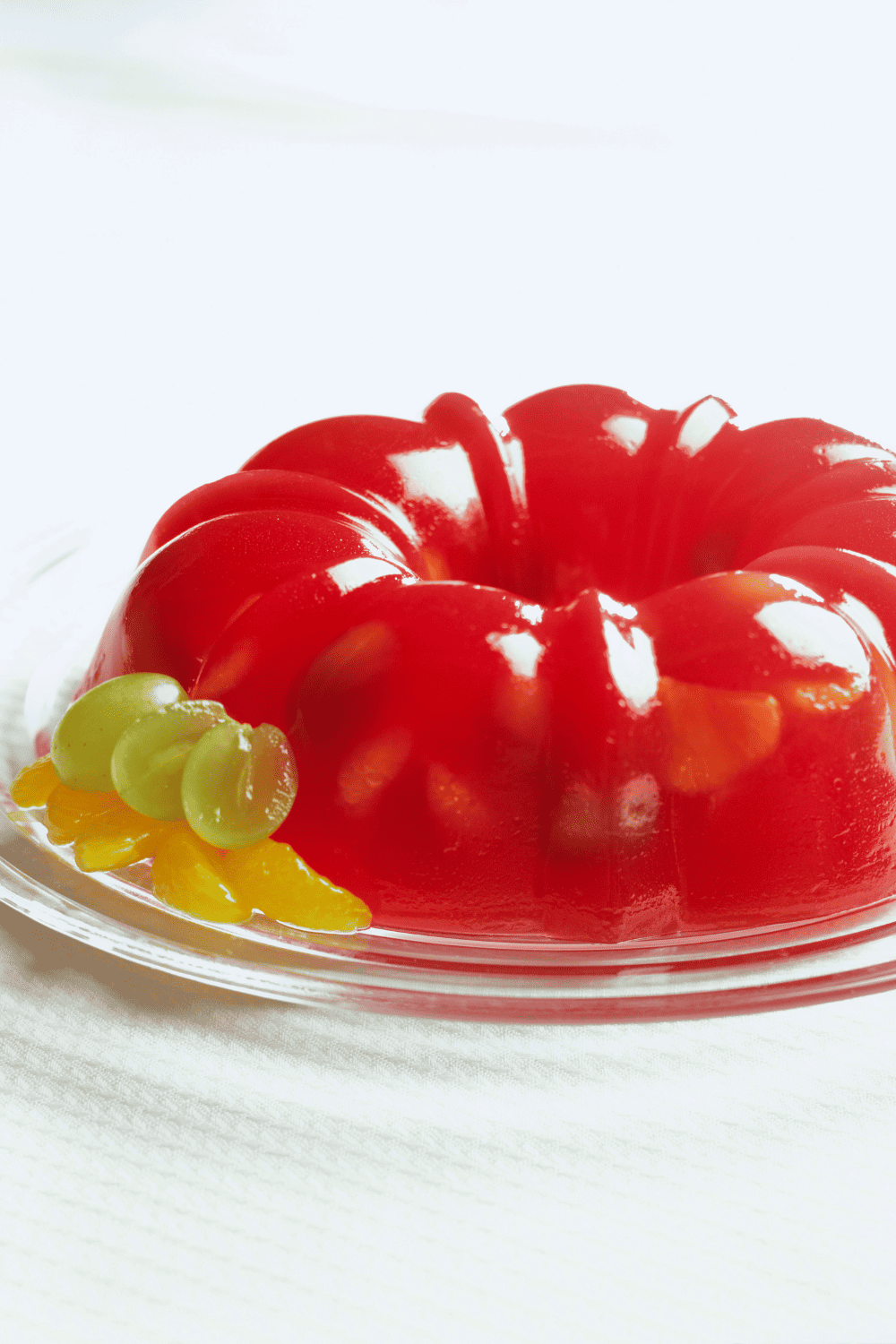 christmas jello mold holiday vintage recipe red jello mold with grapes on a white tray.