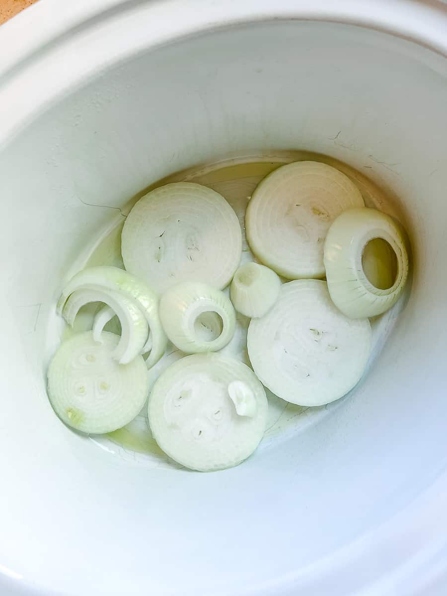 onion in the bottom of white crockpot