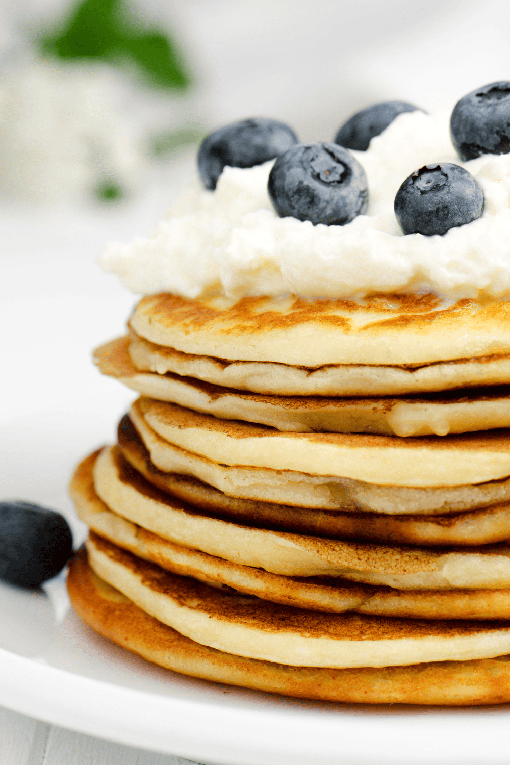Easy Bisquick Pancake Recipe: Ultimate Apple Cinnamon large stack of pancakes with whip topping and blueberries closeup