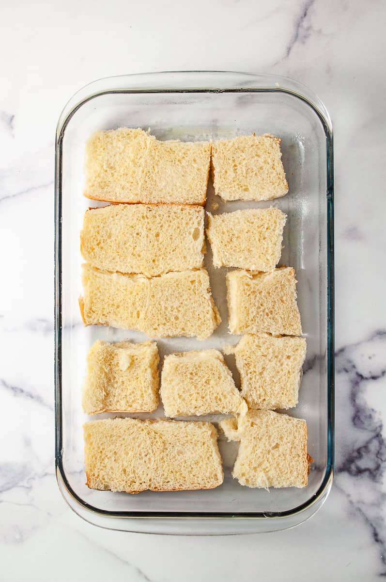 Reuben Sliders Sandwiches: Perfect Party Appetizer 15 sliders in a 13 by 9 baking pan the bottom half of the roll on a white counter.