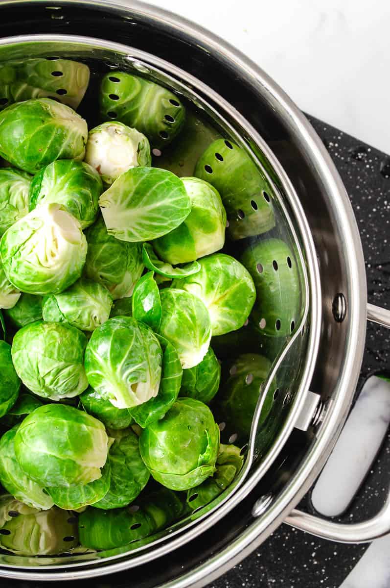 Easy Crispy Parmesan Smashed Brussels Sprouts fresh washed sprouts in a cooking pot that has a self draining inner pot.