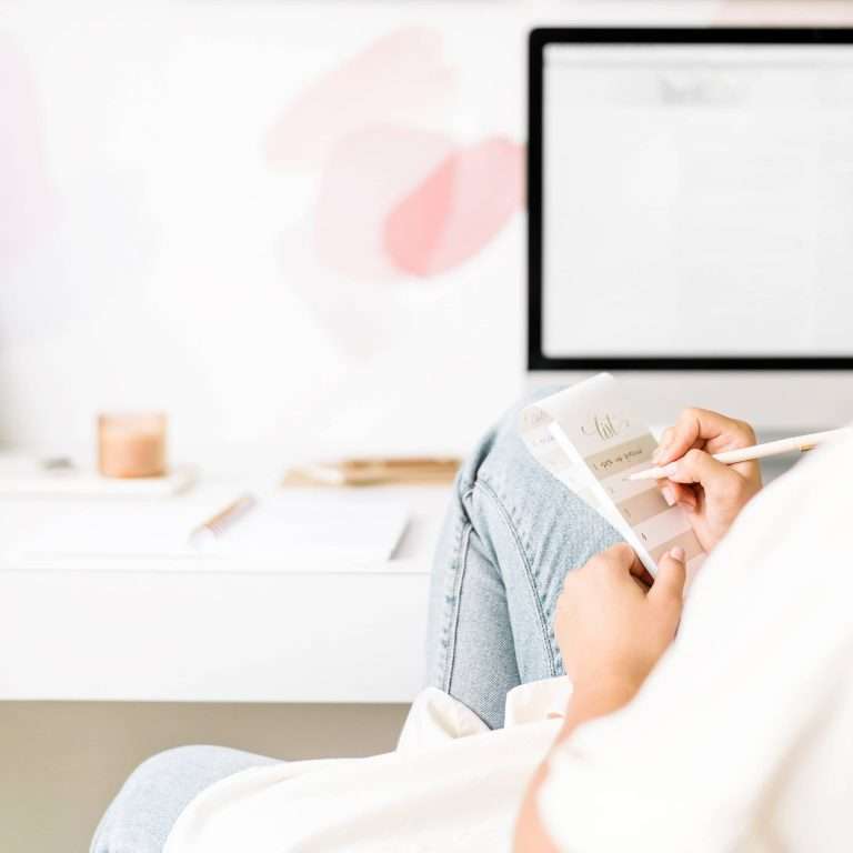 woman writing in a notepad setting her goals