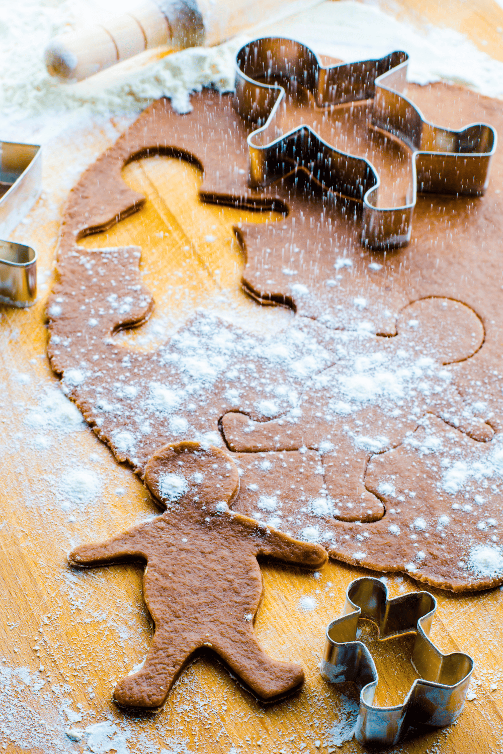 Soft Gingerbread Cutout Cookies β Gingerbread Men dough on a wooden counter with gingerbread men cookie cutters.