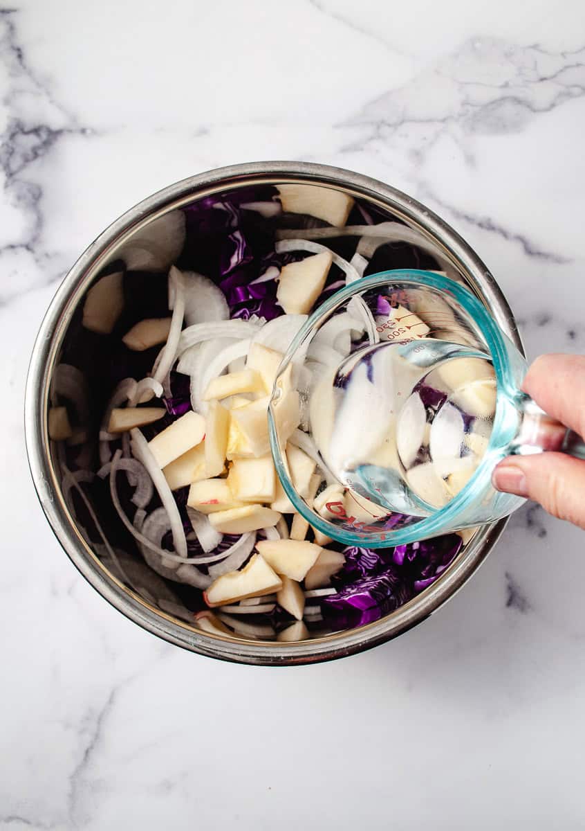 Instant Pot German Red Cabbage with Apple, cabbage, onion, apple and pouring water into the instant pot.