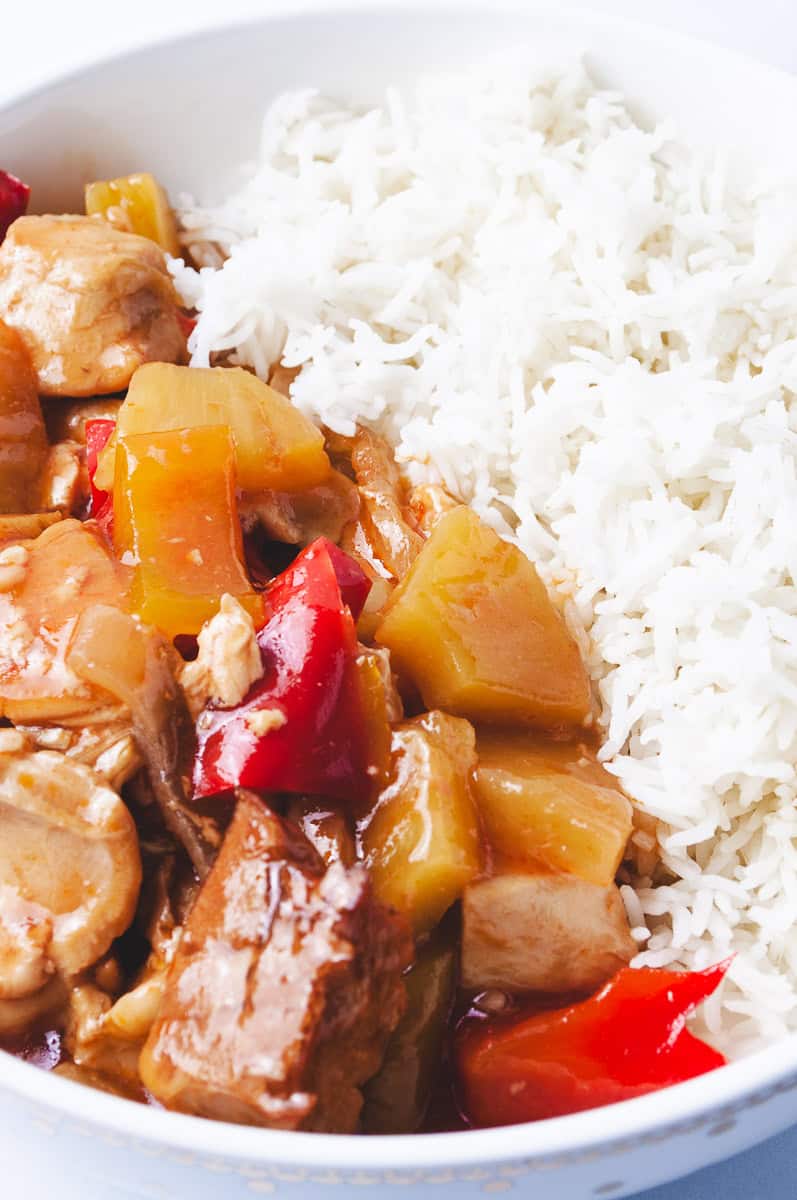 Crockpot Sweet And Sour Chicken with tender chicken pieces, pineapple chunks, and red bell peppers in a rich sour sauce, served with white rice—an easy Sweet Sour Chicken dish perfect for Asian Chicken Crockpot Recipes, Sweet And Sour Recipes, and Chicken Crockpot Recipes Easy.