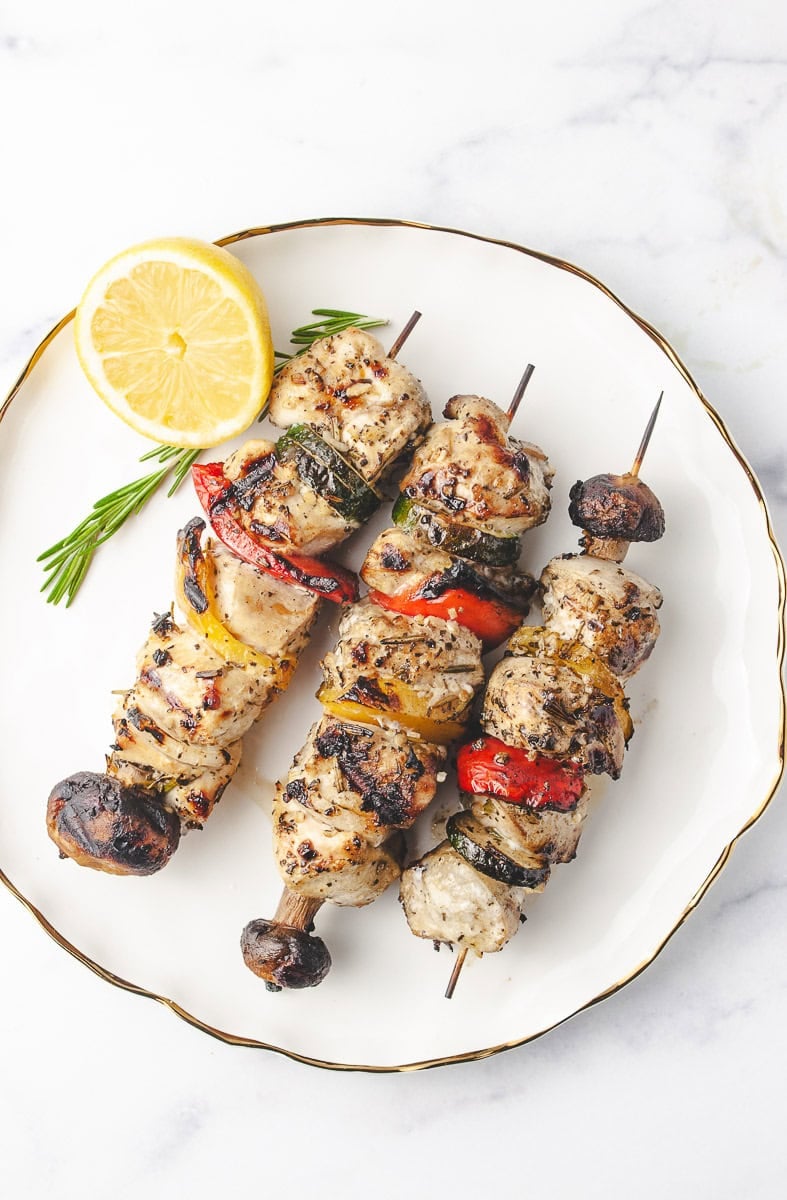 Perfectly cooked chicken skewers with charred edges and colorful vegetables, served on a white plate with lemon and rosemary—an ideal grilled chicken skewers presentation. This flavorful chicken skewer recipe is great for skewer recipes lovers and perfect for making chicken skewers on the grill or preparing ahead for the skewers grill.