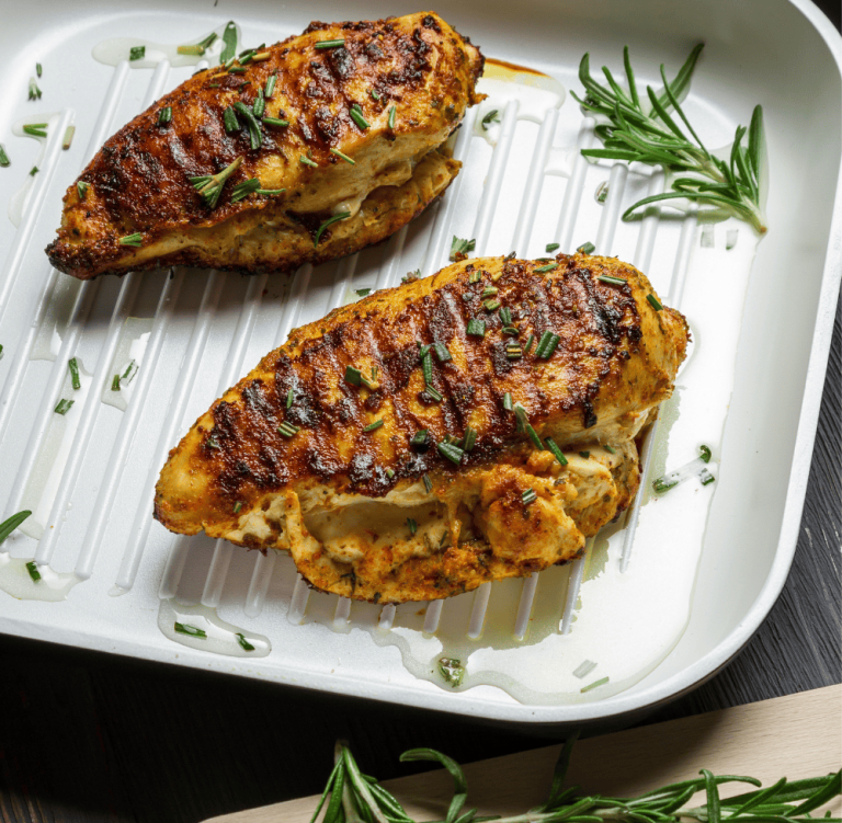Golden, juicy chicken breasts grilled with a rosemary balsamic marinade, served in a white grill pan and garnished with fresh chopped rosemary. This flavorful grilled rosemary chicken highlights the perfect blend of tangy balsamic rosemary chicken flavor and aromatic herbs, ideal for your go-to grilled chicken recipes.