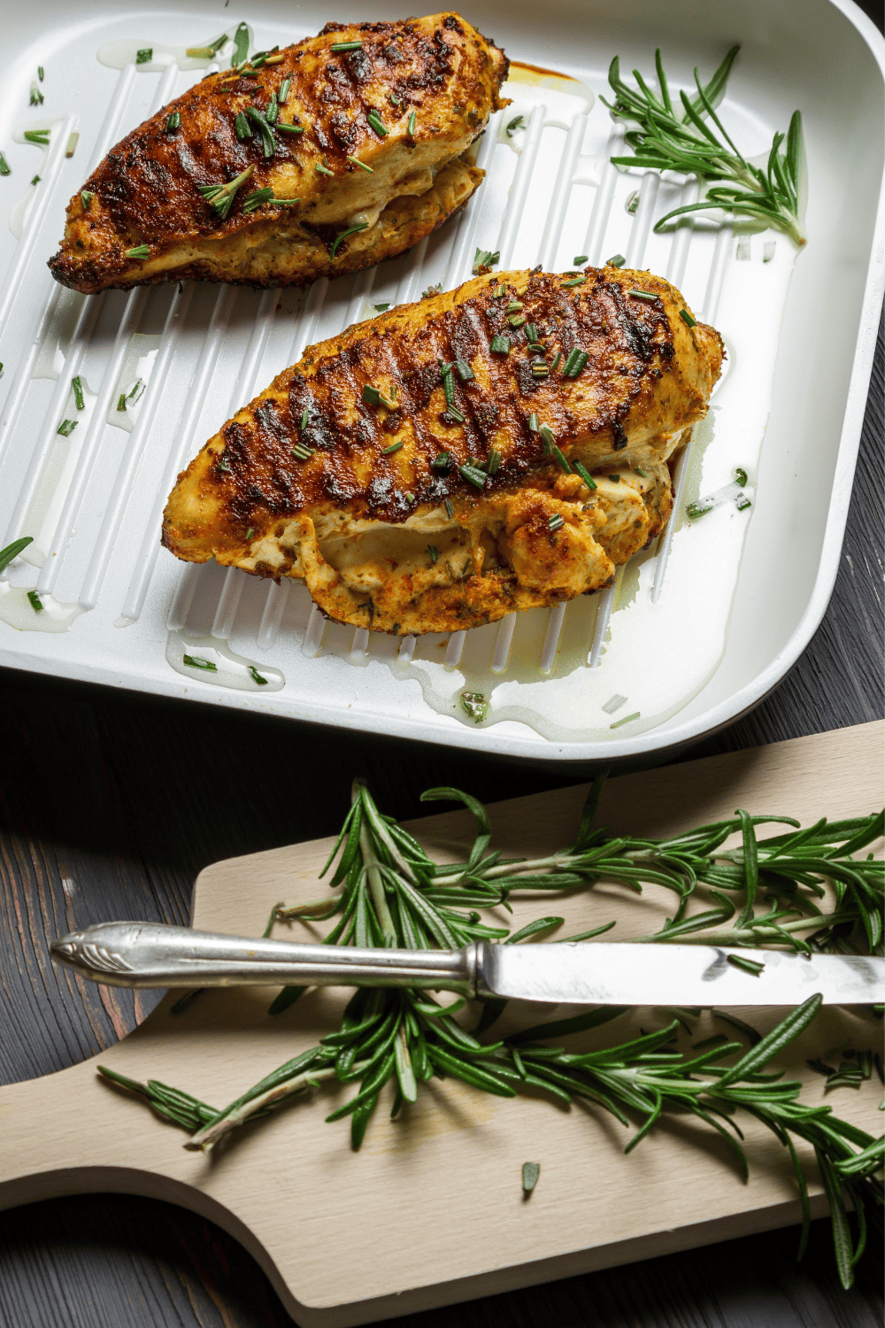 Golden, juicy chicken breasts grilled with a rosemary balsamic marinade, served in a white grill pan and garnished with fresh chopped rosemary. This flavorful grilled rosemary chicken highlights the perfect blend of tangy balsamic rosemary chicken flavor and aromatic herbs, ideal for your go-to grilled chicken recipes.