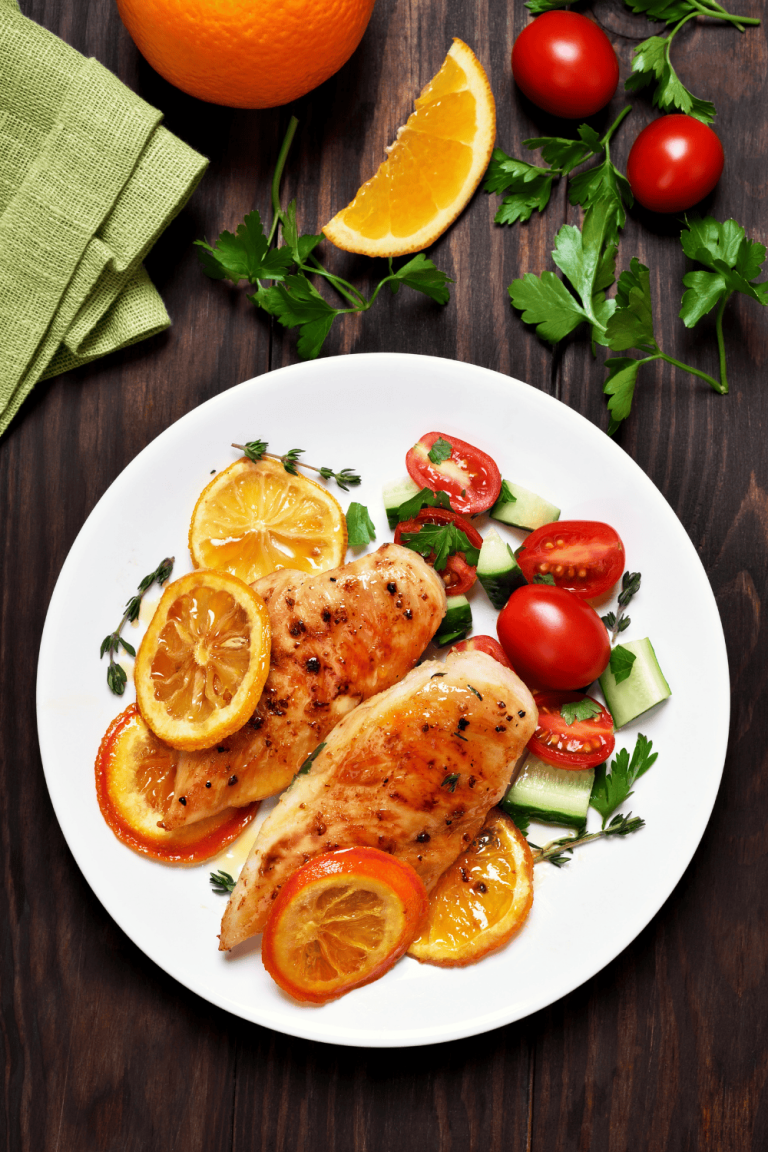 Grilled chicken breasts glazed in a golden orange chicken marinade, garnished with slices of fresh orange and served alongside a crisp cucumber and tomato salad. This bright and juicy citrus chicken marinade combines sweet orange juice chicken marinade flavor with a hint of spice, perfect for a zesty orange ginger chicken dinner.