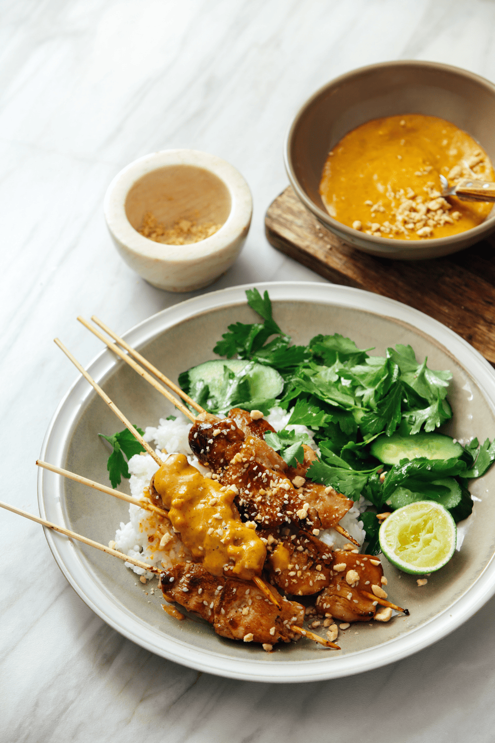Grilled skewers of juicy Thai peanut chicken served over rice with fresh cucumber, herbs, lime, and creamy peanut sauce chicken drizzled on top. This flavorful bowl brings together classic Thai chicken recipes with bold peanut chicken flavor, perfect for a healthy and vibrant dinner.