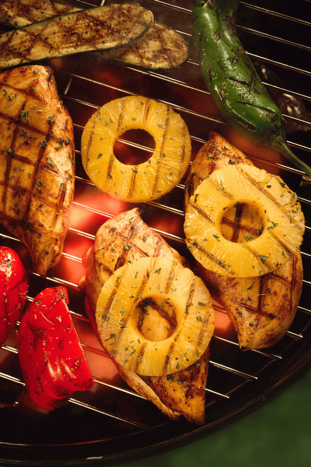 Grilled chicken breasts topped with juicy pineapple rings on a hot grill, surrounded by charred vegetables, all infused with a sweet and savory pineapple teriyaki chicken flavor. This tropical-style pineapple marinade for chicken brings bold, juicy flavor to every bite, perfect for your next grilled teriyaki chicken or summer cookout with a tangy teriyaki marinade twist.
