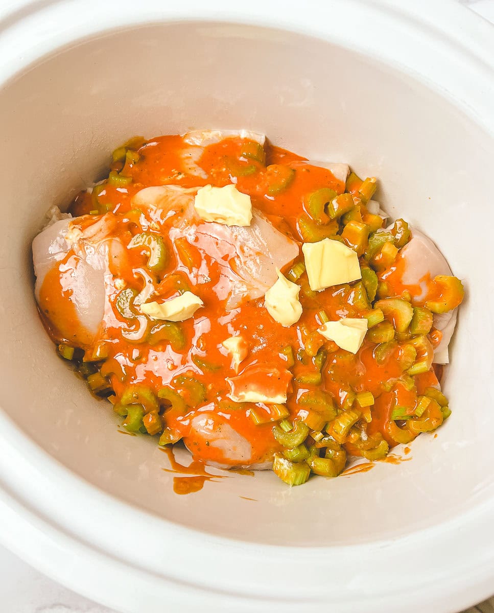 Prepare to savor the spicy goodness of Buffalo Chicken Sliders with this Crockpot Buffalo Chicken recipe! In a slow cooker, chicken breasts are nestled with sliced celery and onions, generously coated in tangy Buffalo wing sauce, and topped with pats of butter for extra richness. This Slow Cooker Buffalo Chicken setup ensures tender, juicy Shredded Buffalo Chicken that’s perfect for Buffalo Chicken Sliders Crock Pot magic.