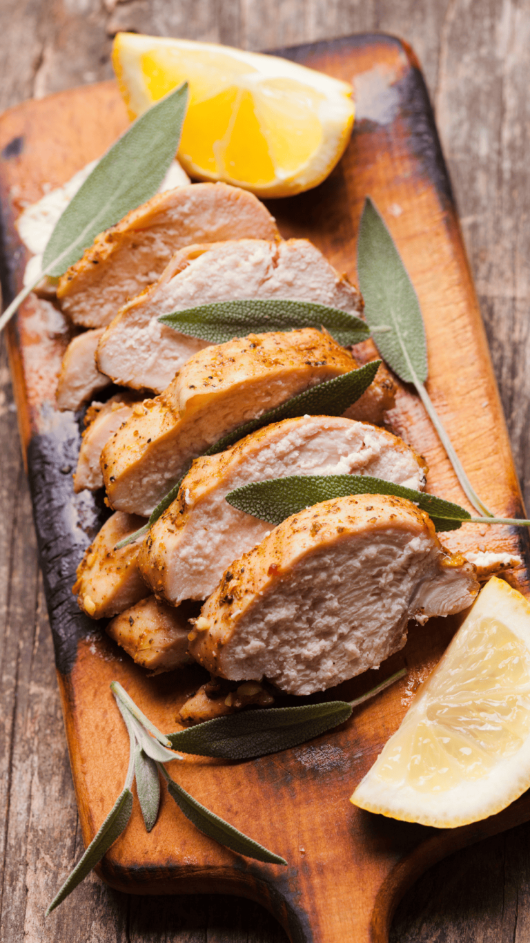 Sliced grilled chicken breast on a wooden cutting board, garnished with fresh sage leaves and lemon wedges. The chicken was prepared with a Chicken Marinade With Lemon and cooked to perfection, resulting in tender, juicy bites. This Lemon Grilled Chicken Marinade combines citrus flavors and herbs, making it one of the Best Chicken Marinade options for summer meals. A bright and fresh Lemon Chicken Marinade For The Grill brings out bold flavors, perfect for family dinners or entertaining. If you're looking for an easy Lemon Herb Chicken Marinade or a refreshing Citrus Chicken Marinade For The Grill, this recipe is a must-try. Perfect Grilled Chicken like this belongs in your collection of go-to Chicken Marinade Recipes.