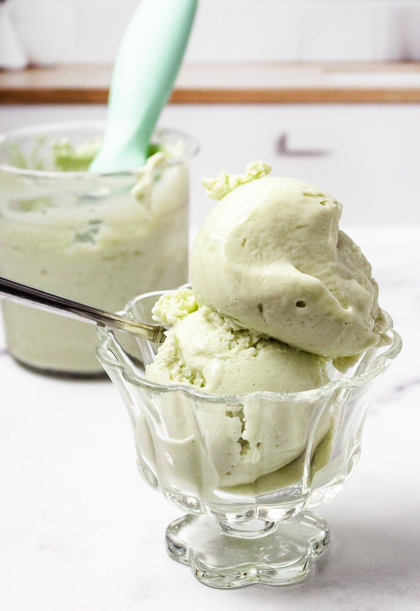 Scoops of creamy Pistachio Protein Ice Cream in a glass dish, made with sugar-free pistachio pudding, unsweetened almond milk, and blended in a Ninja Creami. A perfect example of a Pistachio Ninja Creami Recipe that’s ideal for Healthy Ice Cream Recipes and Sugar Free Ice Cream lovers.