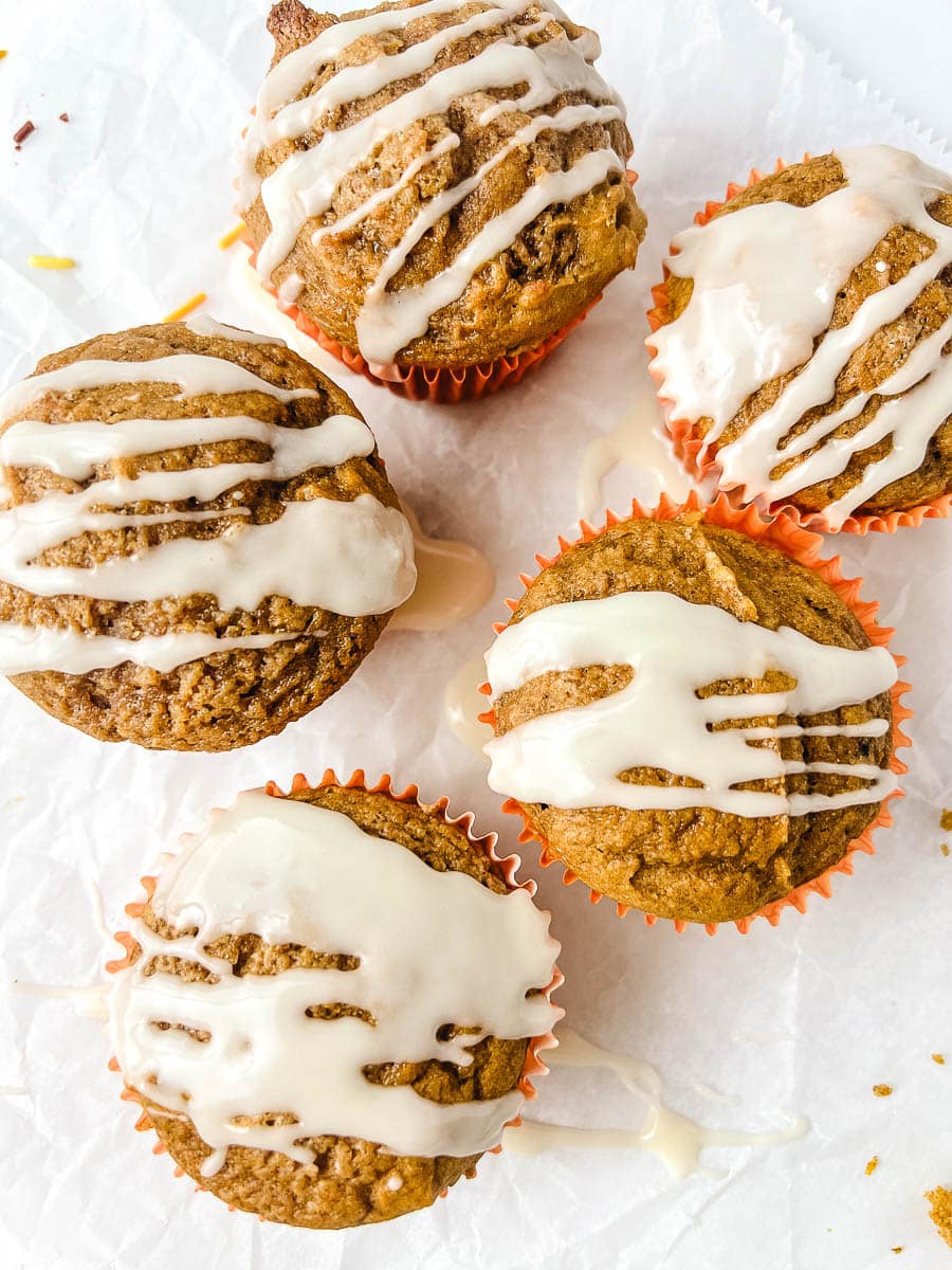 Homemade pumpkin muffins with spice cake mix drizzled with maple glaze, easy 3 ingredient pumpkin muffins recipe for a cozy fall dessert.
