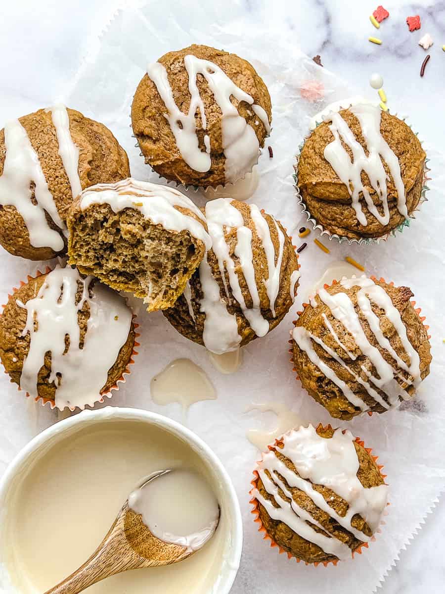Overhead view of easy pumpkin muffins made with spice cake mix, drizzled with maple glaze, a simple ingredient pumpkin muffin recipe for a cozy fall dessert.