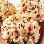These gooey Halloween marshmallow popcorn balls are loaded with melted marshmallows, colorful Halloween sprinkles, candy eyes, and festive candies perfect for a spooky season movie night or Halloween party for kids! This no-bake Halloween dessert is fun to make and even more fun to eat.