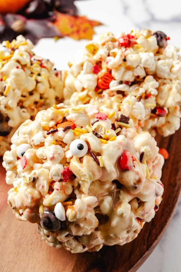 These gooey Halloween marshmallow popcorn balls are loaded with melted marshmallows, colorful Halloween sprinkles, candy eyes, and festive candies perfect for a spooky season movie night or Halloween party for kids! This no-bake Halloween dessert is fun to make and even more fun to eat.