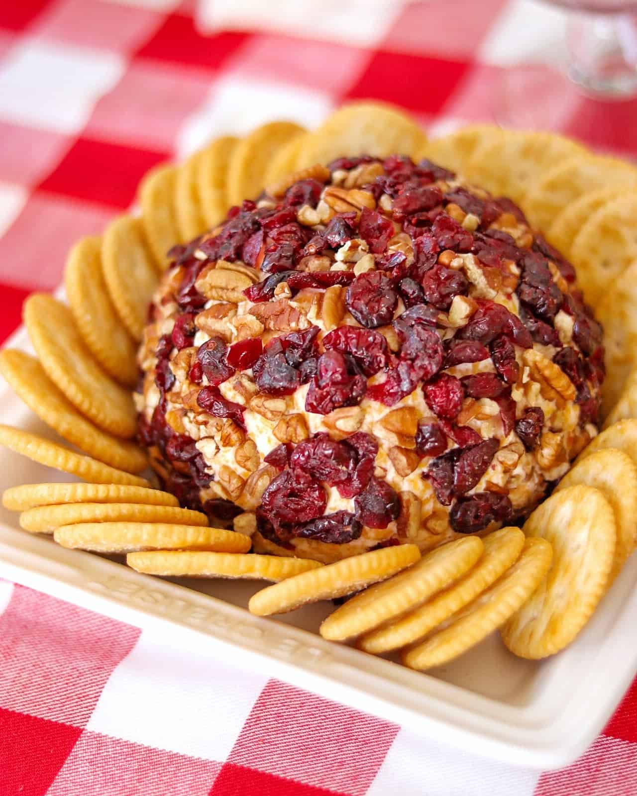 Cranberry Cheese Ball recipe made with pecans and dried cranberries, served with crackers for festive appetizers for party and seasonal cheese ball recipes.