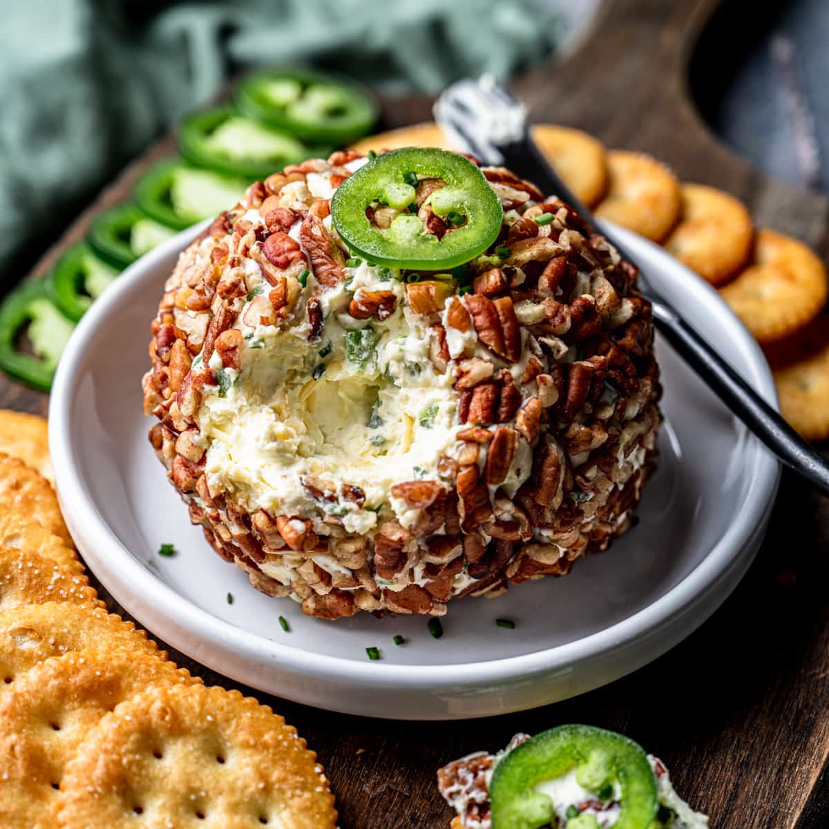 Pecan JalapeΓ±o and Gouda Cheese Ball topped with sliced jalapeΓ±o and coated in pecans β a spicy, creamy favorite among cheese ball recipes and best appetizer recipes.