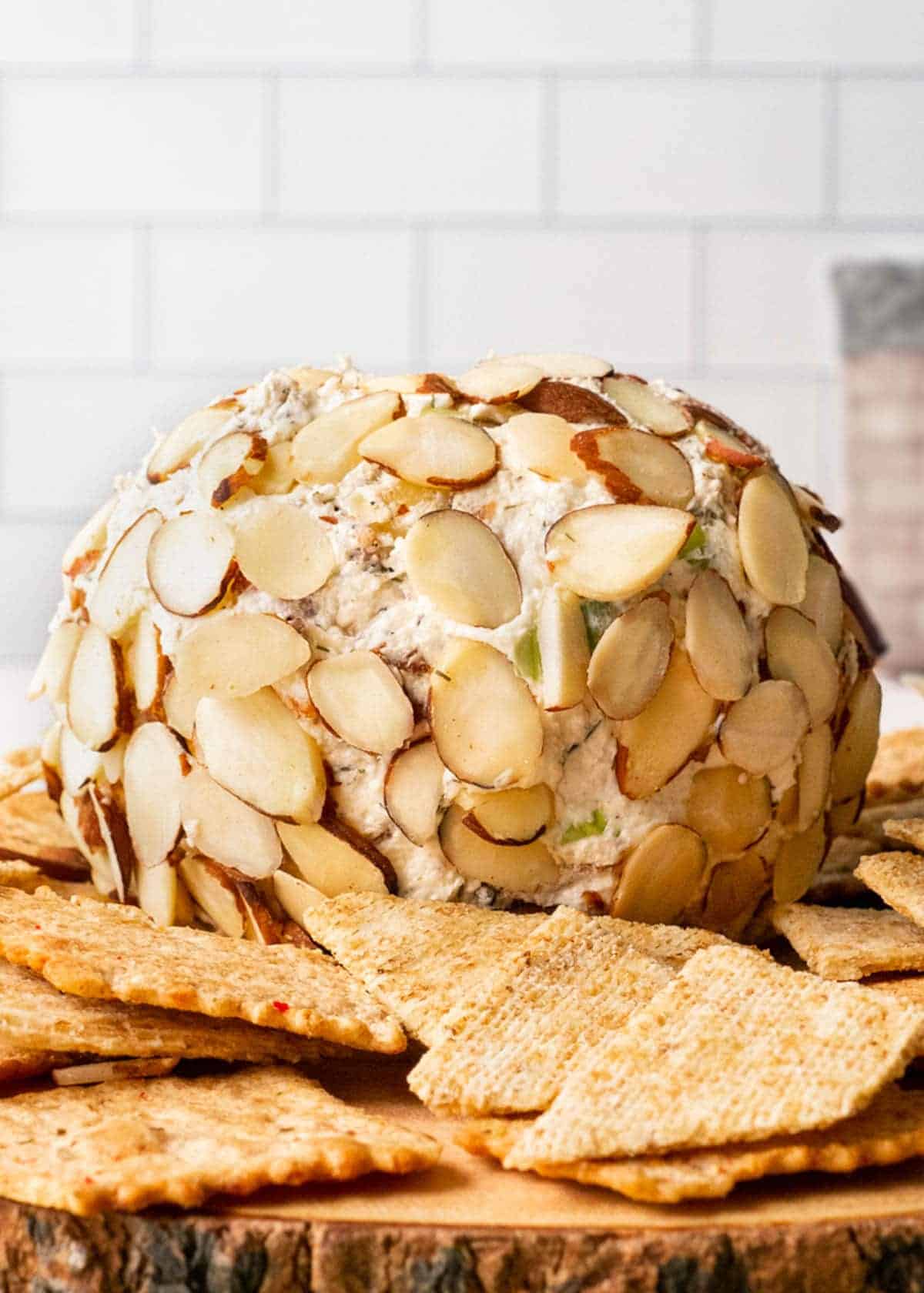 Nutty Bacon Cheese Ball coated in sliced almonds and served with crackers β a flavorful option for cheese ball recipes and appetizers for party gatherings.