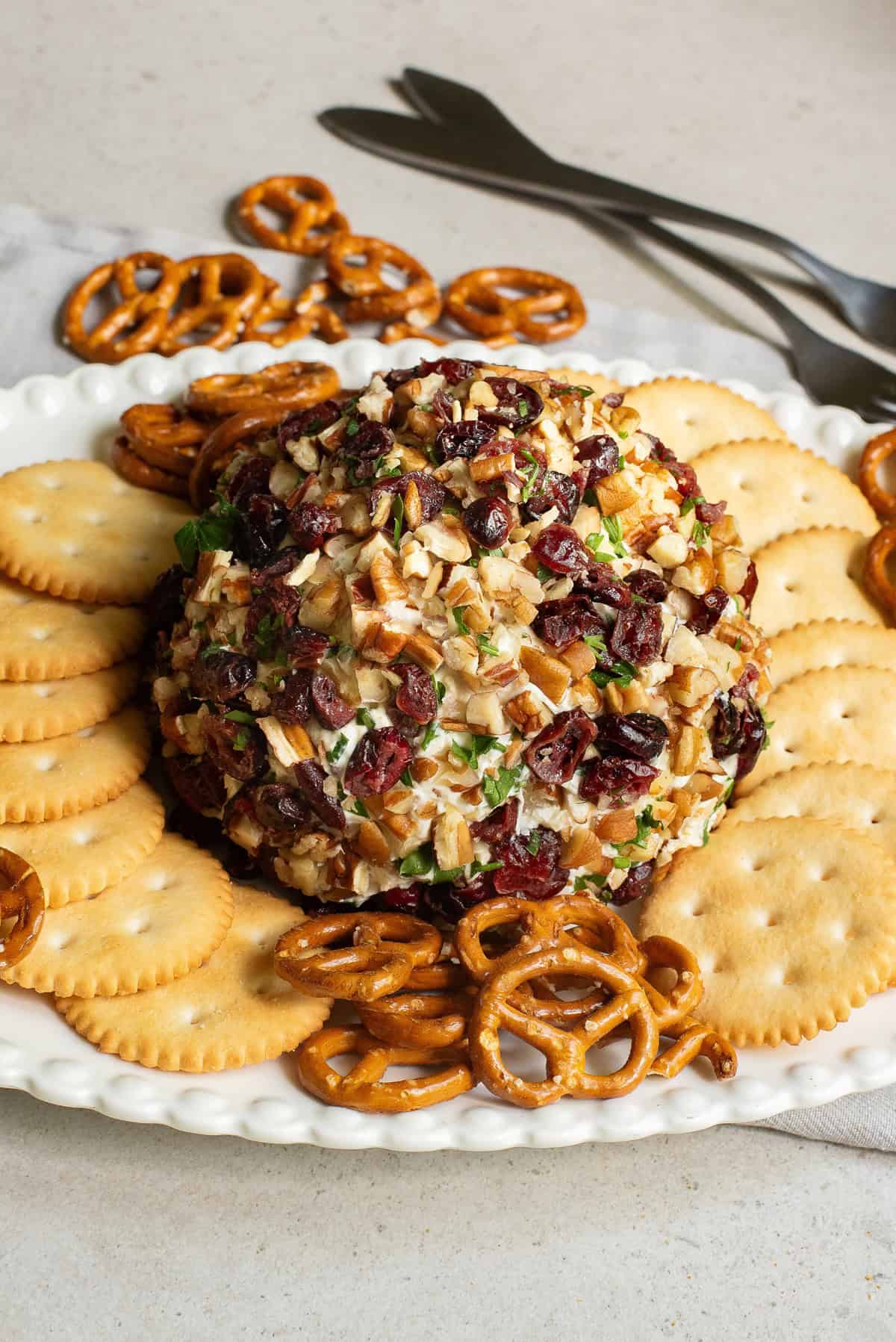 Cranberry Pecan Cheese Ball rolled in chopped nuts and dried cranberries, served with crackers and pretzels a festive favorite among holiday cheese balls and simple cheese ball recipes easy for entertaining.