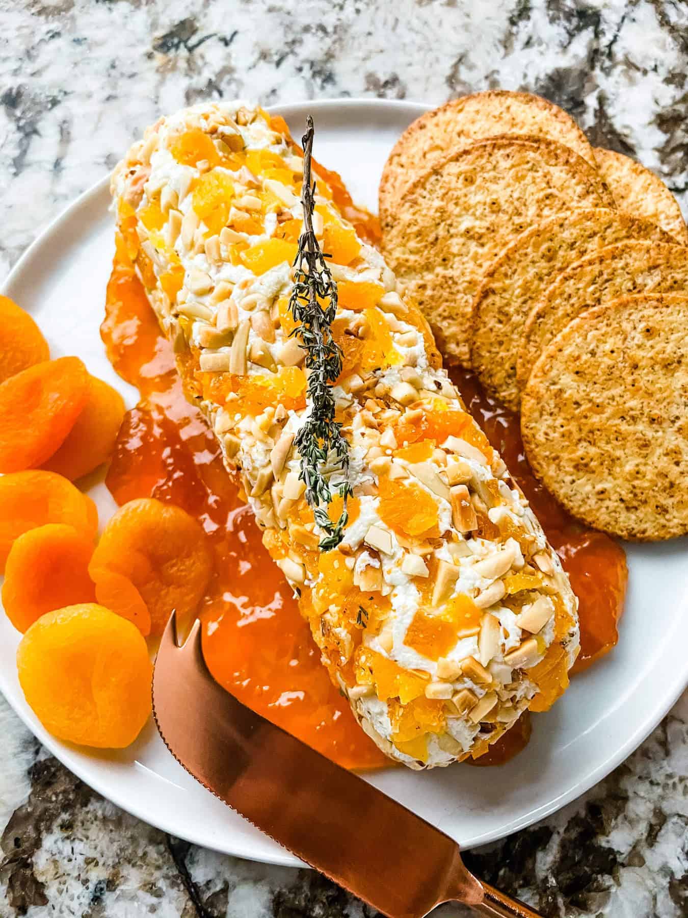 Apricot Almond Goat Cheese Log topped with dried apricots and chopped almonds, served with crackers an easy and festive holiday appetizer.