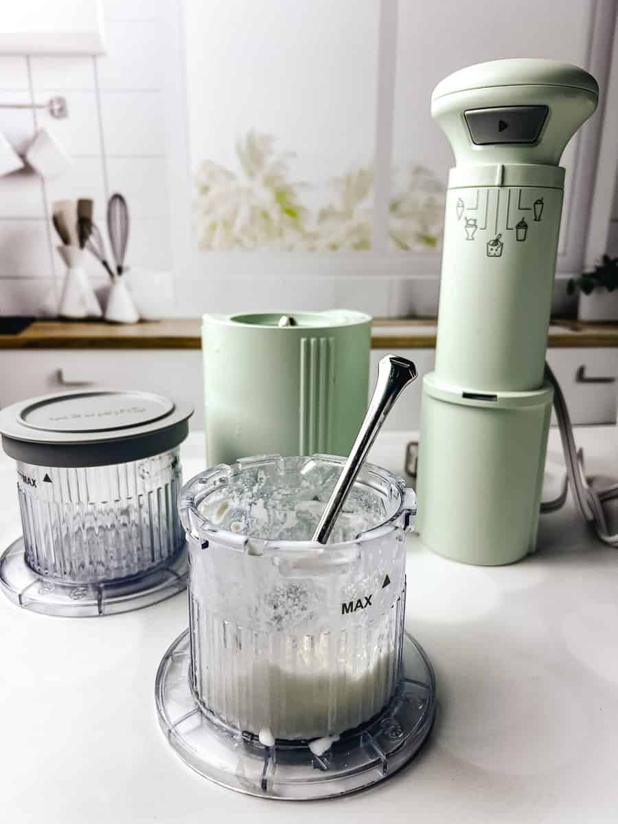 Mint chocolate chip ice cream mixture inside the clear freezing container of a Cuisinart ice cream maker, shown with the motor base and parts used for making homemade ice cream.
This mint chip ice cream recipe is prepared in a Cuisinart ice cream machine as part of easy ice cream maker recipes.