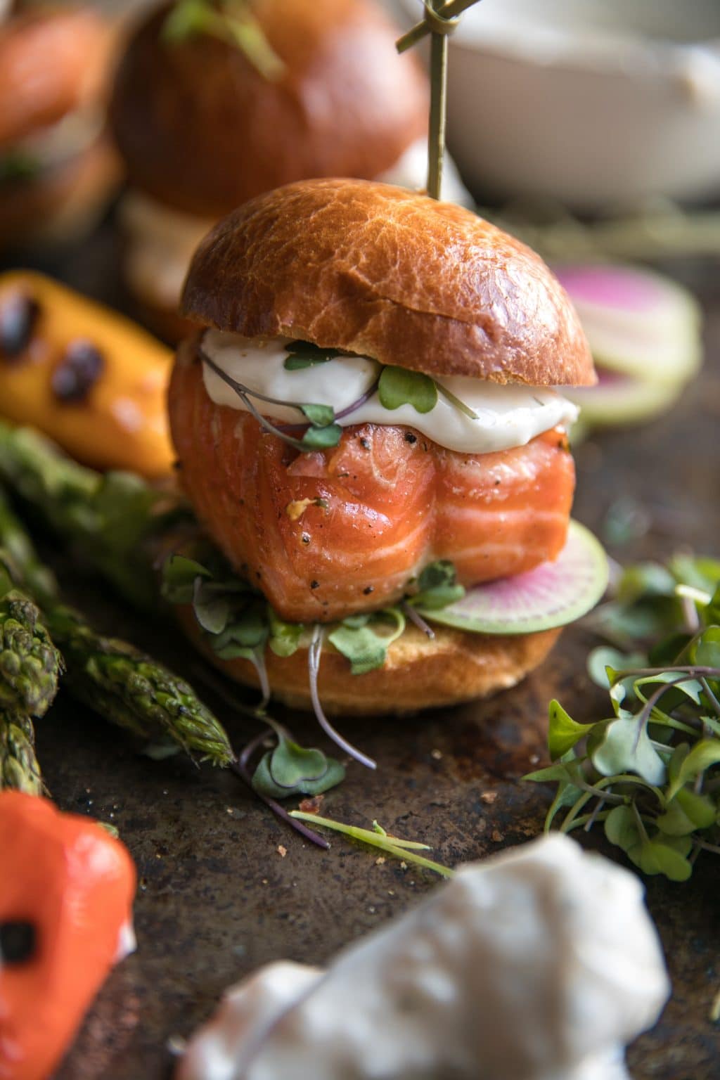 Salmon burger sliders with sauce and veggies. 