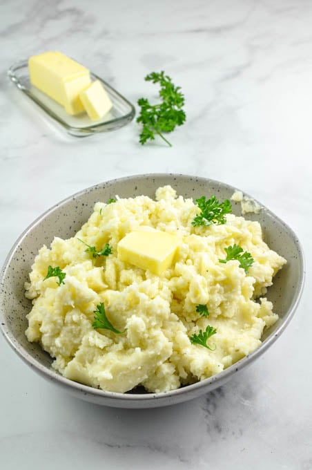 Fluffy homemade mashed potatoes in a speckled serving bowl