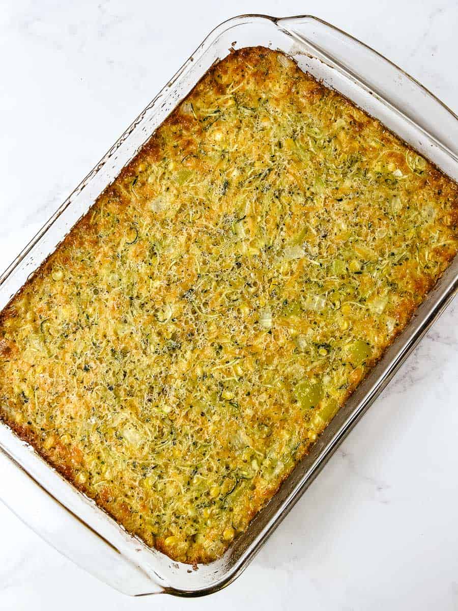 Cheesy zucchini cornbread casserole squares on a vintage floral plate with the browned top crust facing up